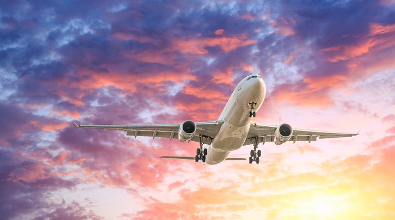 Commercial airplane flying in beautiful sky at sunset,travel concept.